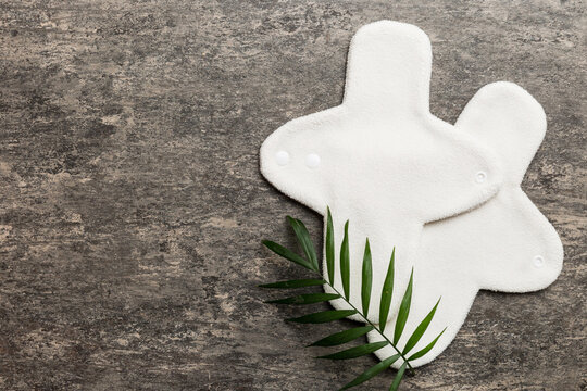 lean feminine sanitary napkin with green leaf. Absence of menstruation in woman. Minimal concept of female menopause. Copy space top view