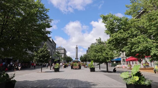 Montreal, Quebec, Canada - 17 June 2026: View of Place Jacques-Cartier in Old Montreal with historic stone buildings, lush trees, and people walking.