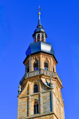 Obraz premium Der markante barocke Kirchturm der Stadtpfarrkirche Mariä Himmelfahrt gegen einen tiefblauen Himmel in Bad Königshofen im Grabfeld, Bayern