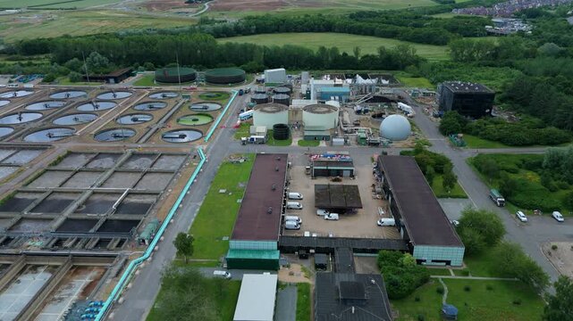 Aerial view of anaerobic digester tanks, biogas spheres, and sludge processing infrastructure at wastewater treatment works in Milton Keynes, UK.