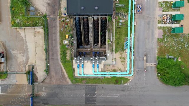 Aerial view of a massive Archimedes screw pump lifting wastewater at a sewage treatment works for urban sanitation, Milton Keynes, UK.