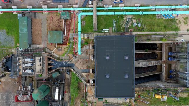 Aerial view of a massive Archimedes screw pump lifting wastewater at a sewage treatment works for urban sanitation, Milton Keynes, UK.