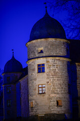 Fototapeta premium Historisches Wasserschloss Mitwitz mit runden Ecktürmen in der Abenddämmerung (Bayern)