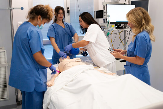 Healthcare professionals training performing cpr on medical mannequin