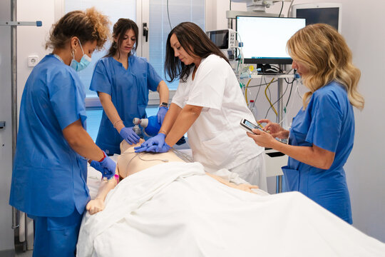 Medical students practicing cpr and resuscitation techniques on dummy