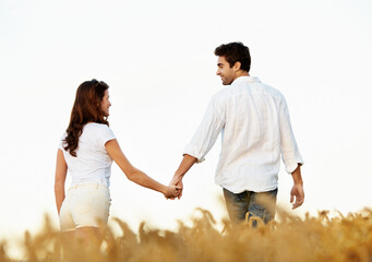 Obraz premium Couple, holding hands and love with walking outdoor, partner and support with care in nature. People, marriage and romantic stroll in meadow for healthy relationship, bonding and together with trust