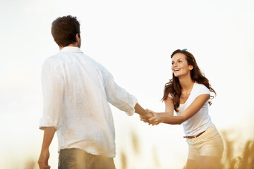 Obraz premium Couple, smile and woman holding hands in meadow, partner and support with care in nature. Female person, happiness and man outdoor for healthy relationship, bonding and together with space in Italy