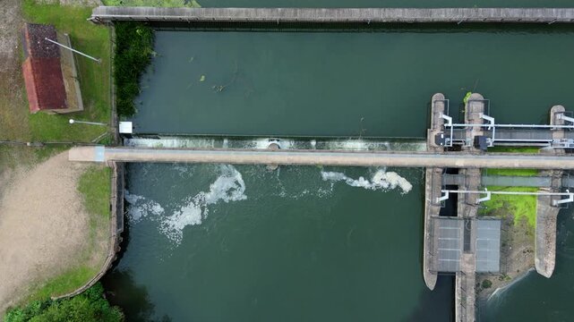 Aerial view of white water rushing over Feildes Weir on the River Lee Navigation for canal flood management near Hoddesdon, Hertfordshire, UK.