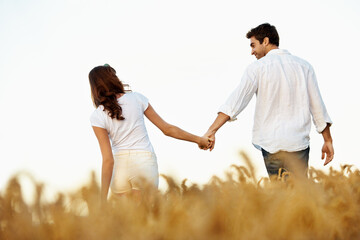 Obraz premium Couple, holding hands and love with walk in meadow, partner and support with care in nature. People, marriage and romantic stroll outdoor for healthy relationship, bonding and together with trust