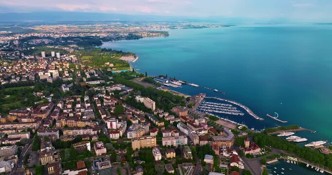 Establishing shot of swiss city Lausanne in summer day. Aerial view of the Switzerland city on the shores of Lake Geneva