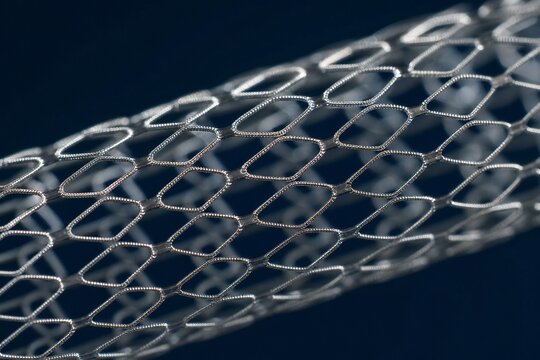 Ultra-fine metallic mesh stent showing intricate lattice on dark blue background.