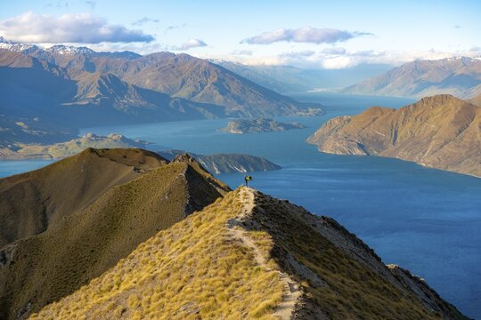 Hiker doing yoga, Mount Roy summit, mountain and lake views, Roys Peak, Lake Wanaka, Southern Alps, Otago, South Island, New Zealand