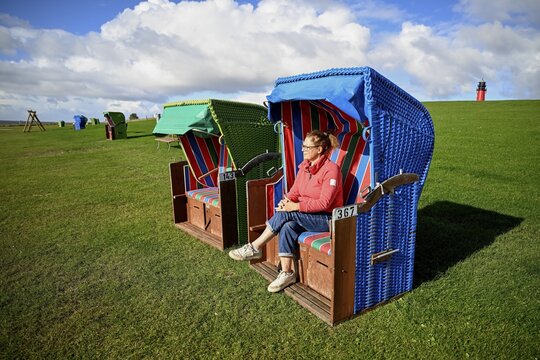 Woman in a beach chair on the island of Pellworm, Wadden Sea National Park, North Frisia, Germany