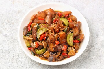Fototapeta premium Oseng kikil, a traditional Indonesian stir-fried beef tendon dish cooked with chili, garlic, shallots, and aromatic spices.