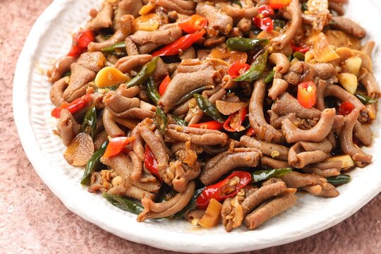 oseng usus ayam, a savory and spicy stir-fried chicken intestine dish cooked with chili peppers, garlic, shallots, sweet soy sauce, and aromatic spices.
