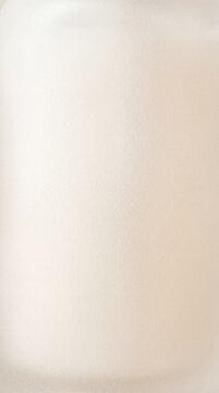 Soft beige textured paper background with smooth velvety texture of frosted surface, subtle gradient and soft lighting creating gentle warm tone and minimal composition