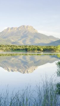 Tranquil Mountain Escape: Crystal Clear Lake with Forest and Peak Views