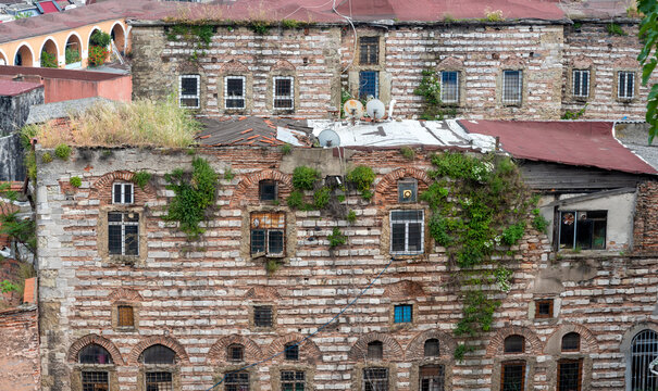 Old stone building with plants growing on the walls in a city with narrow streets during the day
