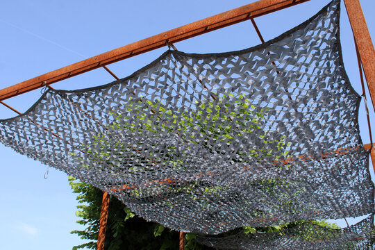 Filet d'ombrage, voile d'ombrage camouflage gris install&eacute; sur une pergola