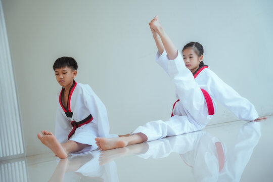Kids practice taekwondo moves in training session at a martial arts dojo during afternoon class