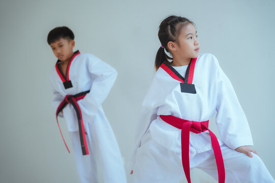 Children practice martial arts in training outfit during lesson in a studio in the afternoon