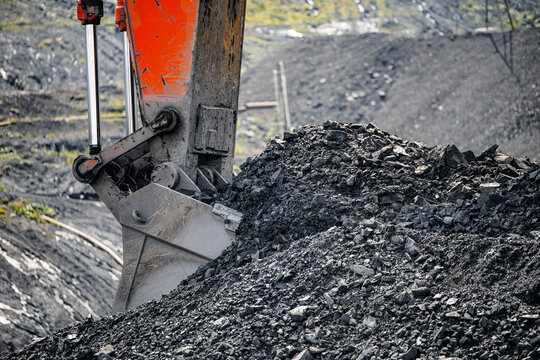 Closeup excavator bucket and coal, Heavy machinery operating in open pit mine