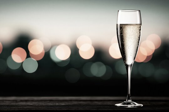 Sparkling drink in a glass on a table with city lights at night