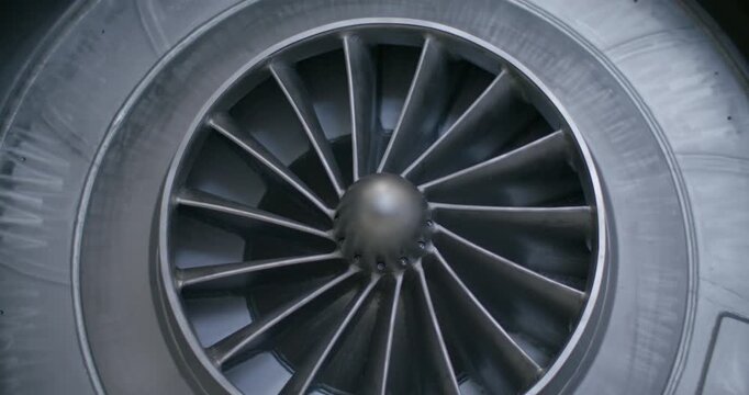Front view of a metallic radial turbine fan spinning inside a heavy industrial housing
