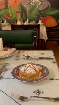 Waiter serving a traditional sweet and savory Moroccan bastilla pastry