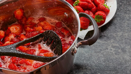 Cooking homemade strawberry jam in metal pot close up © Анатолий Еремин