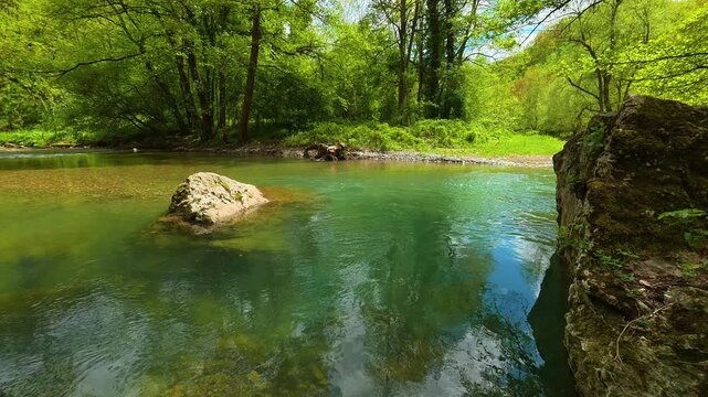 Clear water glows turquoise, reflecting sky. Gradac River, Serbia