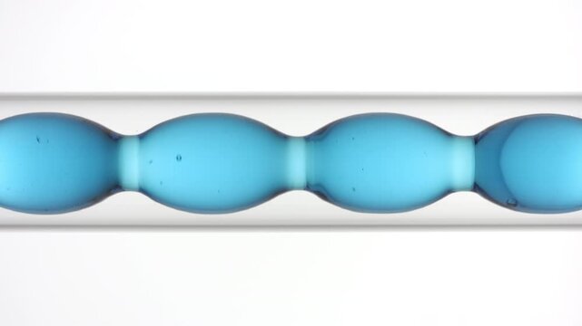 Vertical big focus on air bubbles racing through transparent blue fluid as it fills and drains from a bulb laboratory condenser displayed on white