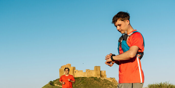 Trail runner checking fitness tracker after outdoor workout