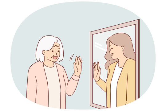 Elderly woman sees past in reflection of mirror, and waves hand, receiving positive emotions