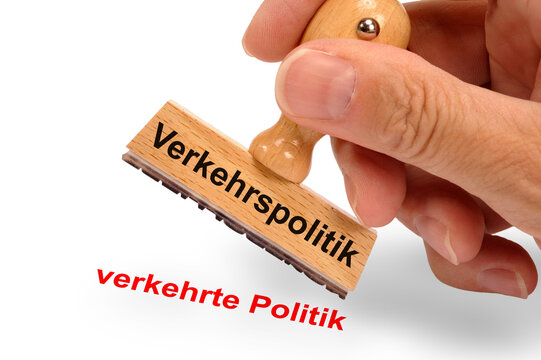 Ein Holzstempel ist beschriftet mit dem Aufdruck: Verkehrspolitik und dem Abdruck verkehrte Politik