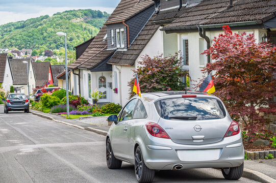 Iserlohn, Germany - June 14, 2026: Silver Opel Corsa decorated with German flags parked on a residential street