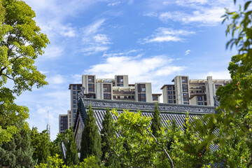 Traditional Chinese Roof and Modern Apartment Buildings in Urban Greenery © LuuDieuThanh