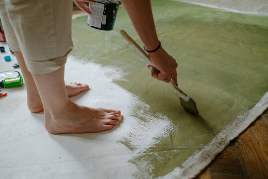 artist painting a white canvas green 