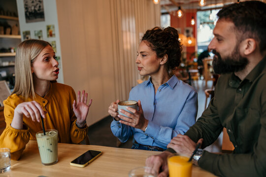Friends enjoying conversation and drinks at a coffee shop
