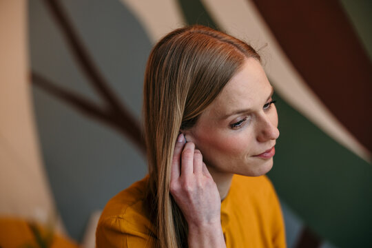 Woman listening to audio using wireless earbud