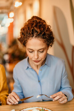 Woman eating main course in restaurant dining