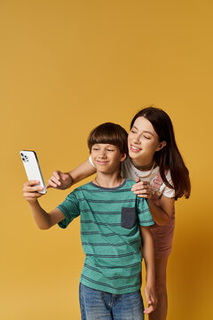 A young mother and her son enjoy taking selfies together, showcasing their playful bond.