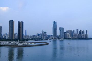 Modern waterfront city skyline with marina and calm bay at dusk © PhungBao