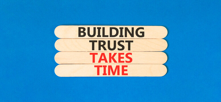 Building trust takes time words symbol. Concept words Building trust takes time on beautiful wooden sticks. Beautiful blue background. Business building trust takes time concept. Copy space.