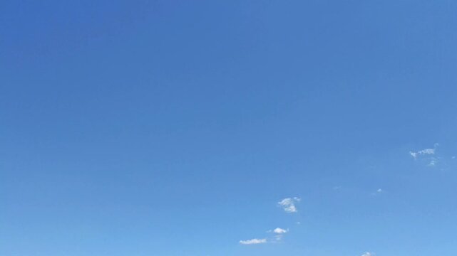 Curious white clouds moving in the blue sky at midday