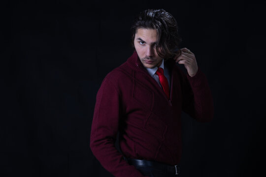 Horizontal fashion portrait ofa young man, creating a casual yet elegant visual, expressing confidence and modern lifestyle in a studio setting with dark background