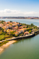 Fototapeta premium A small town situated on the edge of a large body of water, perfect for use in travel or tourism visuals vertical frame