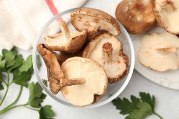 Fototapeta premium Raw shiitake mushrooms and parsley on light grey table, flat lay