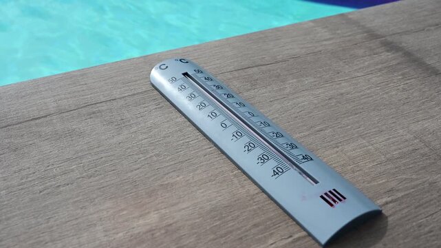 Thermometer and swimming pool in France during a heatwave and the hottest day recorded in the country.