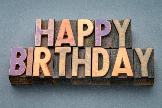 Happy Birthday greeting card in vintage letterpress wood type against slate stone